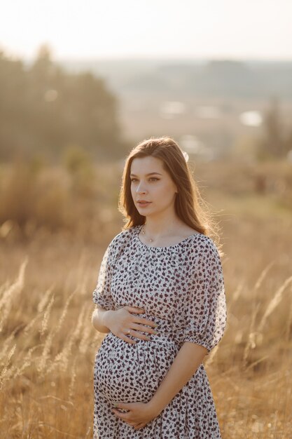 Young pregnant woman relaxing in park outdoors