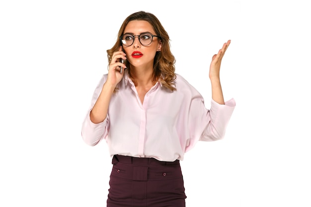 Young pretty business woman talking on the mobile phone, looks confused