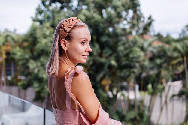 Young pretty caucasian woman alone in summer cute dress on vacation at luxury villa