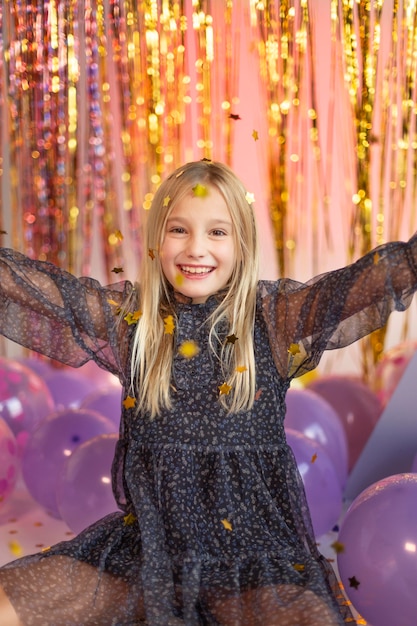 Young pretty girl at festive party with balloons