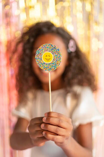 Young pretty girl at festive party with lollipop