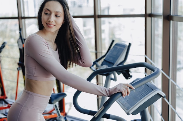 Young pretty girl in sportswear at the gym