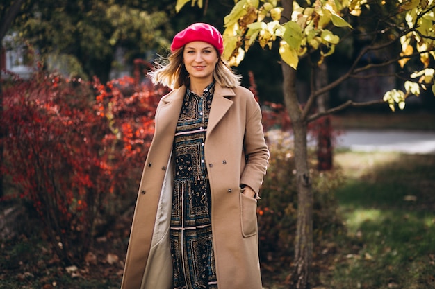 Free photo young pretty lady in a red barret outside in park