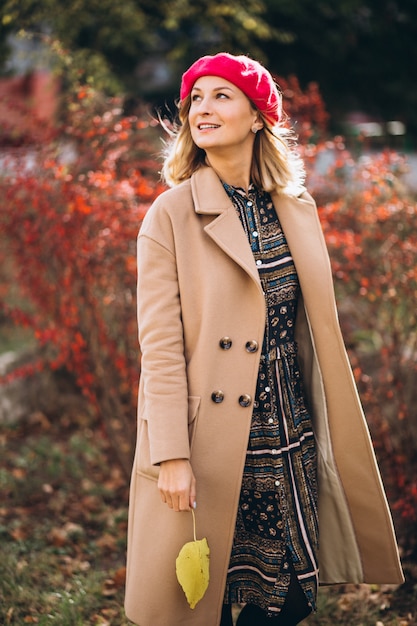 Free photo young pretty lady in a red barret outside in park