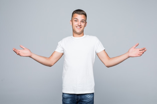 Free Photo young pretty man in a white t-shirt isolated on white hold arms both sides