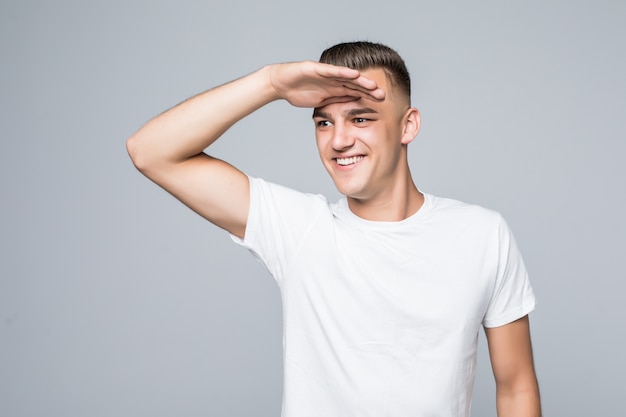 Young pretty man in a white T-shirt isolated on white looks forward