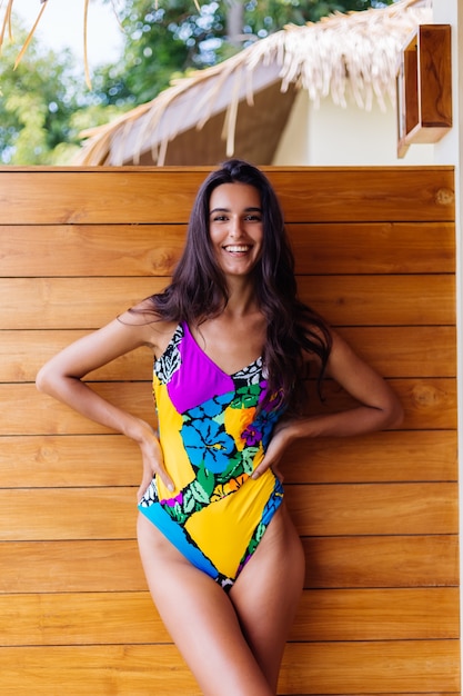 Free photo young pretty positive happy slim woman in colorful swimsuit at luxury amazing hotel villa enjoying beautiful day on vacation in thailand