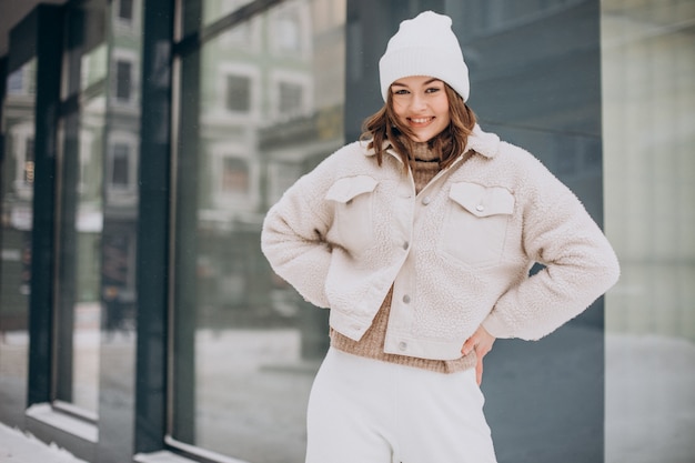 Free photo young pretty woman in beige outfit walking in the street at winter time