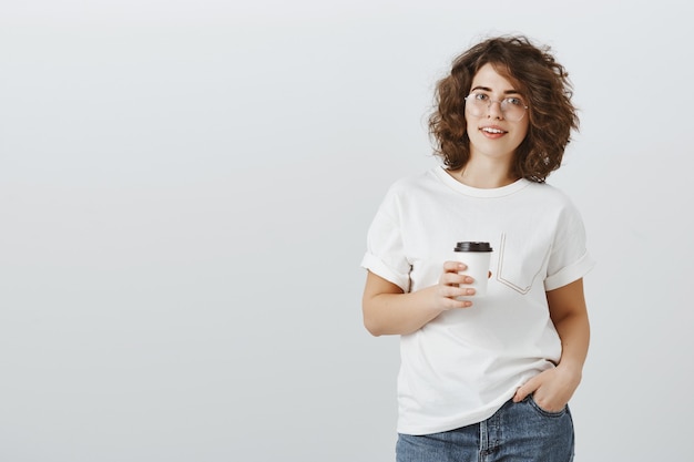 Free Photo young pretty woman in casual outfit drinking coffee on work break