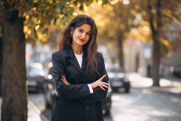 Young pretty woman in classy outfit in an autumn street