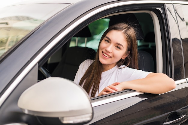 Young pretty woman driving her car on trip road