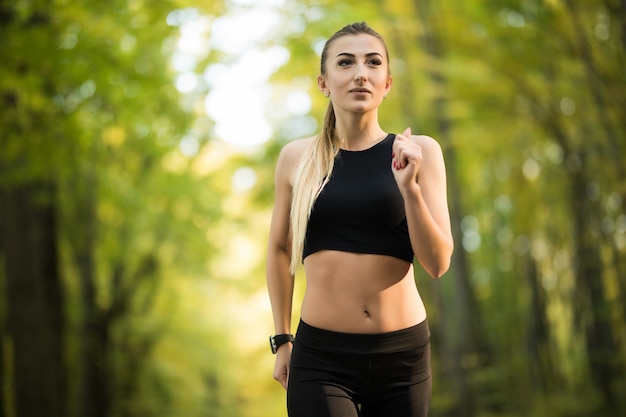 Young pretty woman jogging in the park in summer