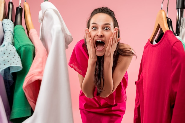 The young pretty woman looking at dresses and try on it while choosing at shop