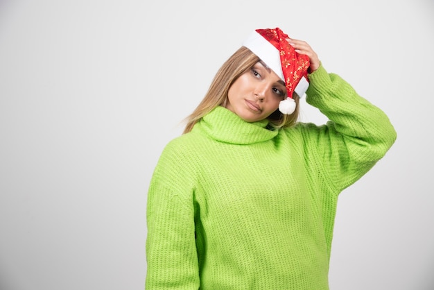 Free photo young pretty woman posing in santa claus red hat .