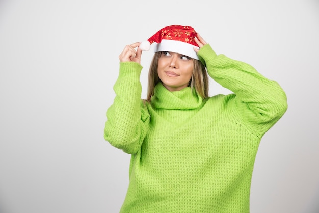 Free photo young pretty woman wearing santa claus red hat .