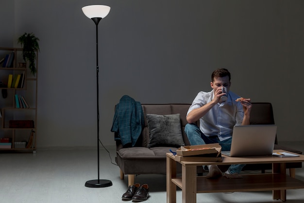 Free Photo young professional having a snack while working from home