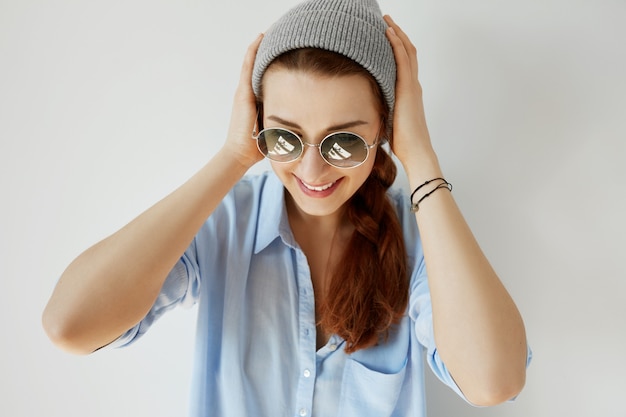 Free photo young redhead girl wearing sunglasses and hat