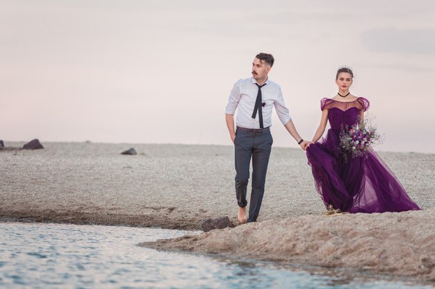 Young romantic couple running on the beach of sea