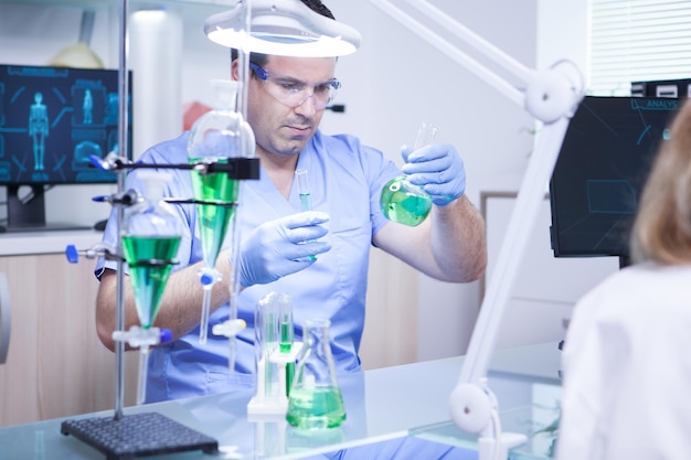 Free Photo young scientist holding two test tubes in a research laboratory. biologist working.