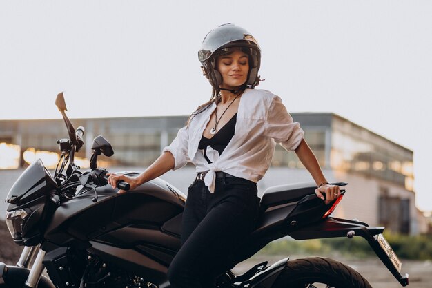 Young sexy female motorcyclist on bike