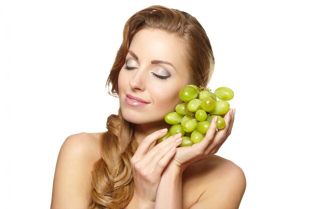 Young sexy smiling beautiful  woman holding a bunch of grape in her hands with long hair isolated on white