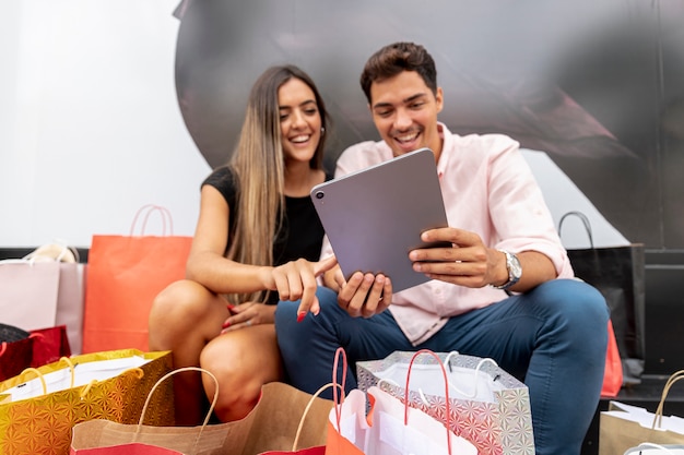 Young shopping couple holding tablet