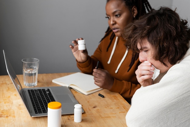 Young sick man and friend having a video call with a doctor