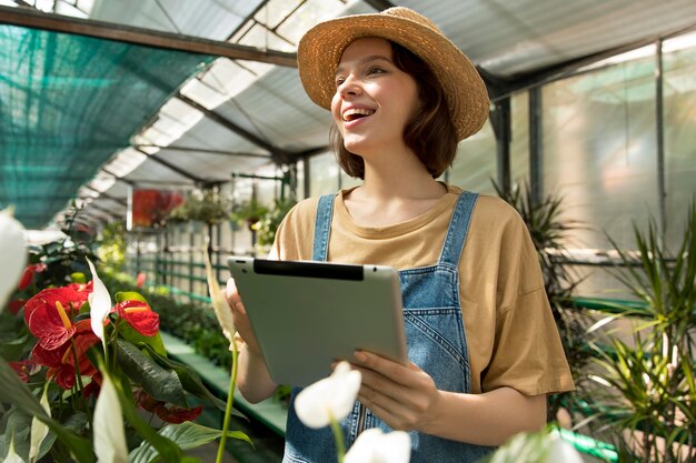 Young smiley woman working in a greenhouse