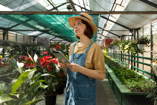 Young smiley woman working in a greenhouse