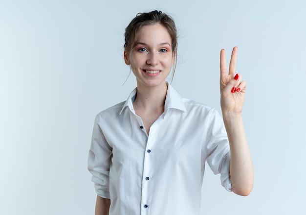 Young smiling blonde russian girl gestures victory hand sign isolated on white space with copy space