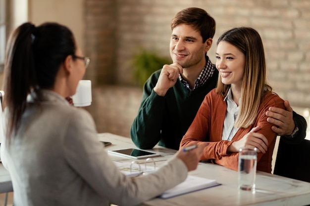 Free photo young smiling couple having a meeting with financial advisor in the office