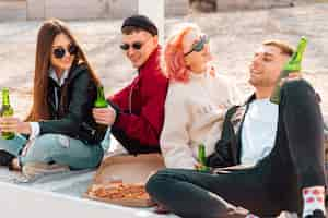 Free photo young smiling friends having party outdoors