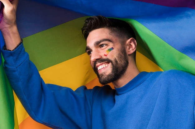 Free Photo young smiling man with lgbt rainbow flag