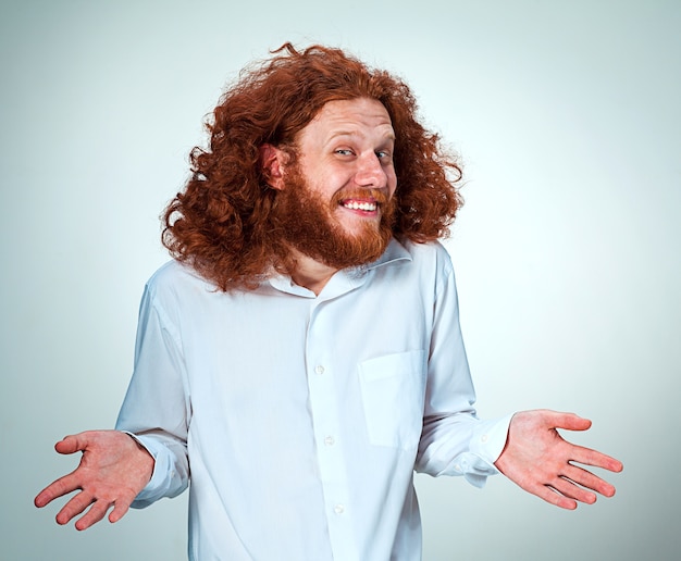 Free photo young smiling man with long red hair looking at camera