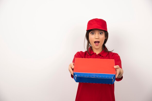 Young smiling woman in red uniform delivering pizza in box.