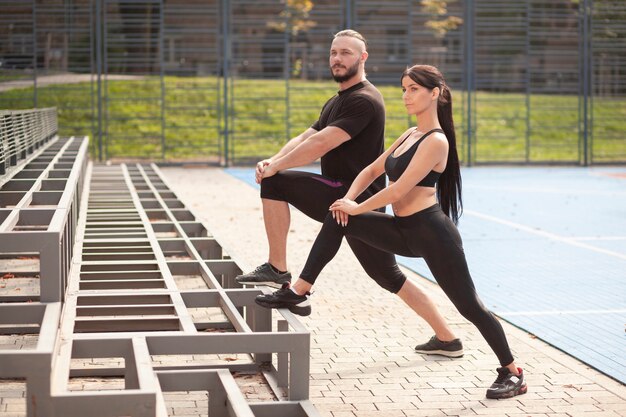 Young sportives at stadium legs exercise