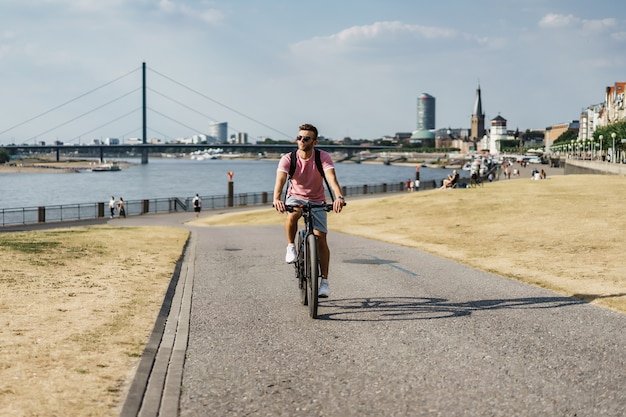 Young sports man on a bicycle in a European city. Sports in urban environments.