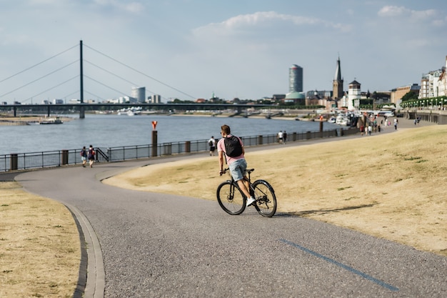 Free photo young sports man on a bicycle in a european city. sports in urban environments.