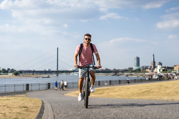 Young sports man on a bicycle in a European city. Sports in urban environments.