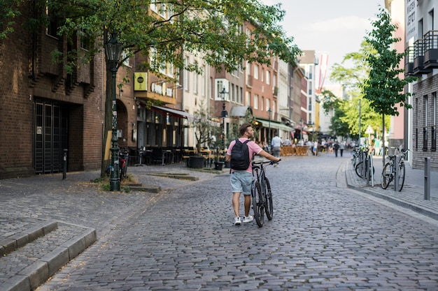 Young sports man on a bicycle in a European city. Sports in urban environments.