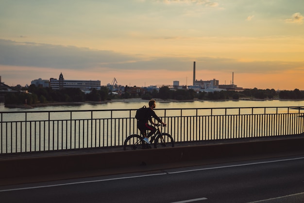 Free photo young sports man on a bicycle in a european city. sports in urban environments.