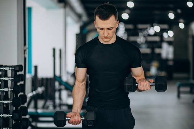 Young sports man training at the gym