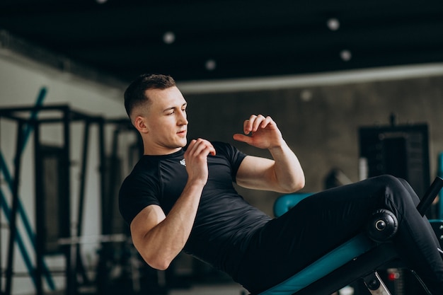 Young sports man training at the gym