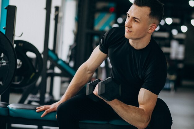 Young sports man training at the gym