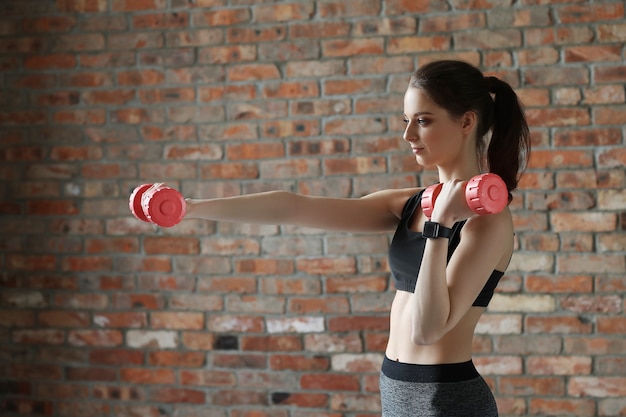 Young sportswoman with dumbbells