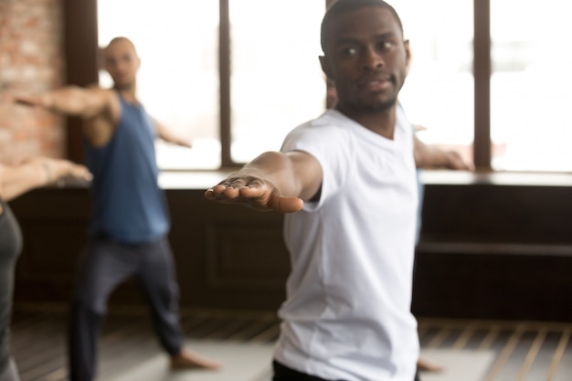 Young sporty black man in Warrior two exercise