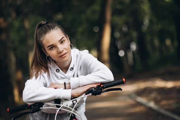 Young sporty woman riding bicycle in the park