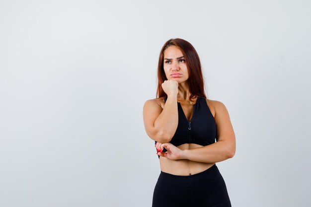 Young sporty woman with long hair in a black top