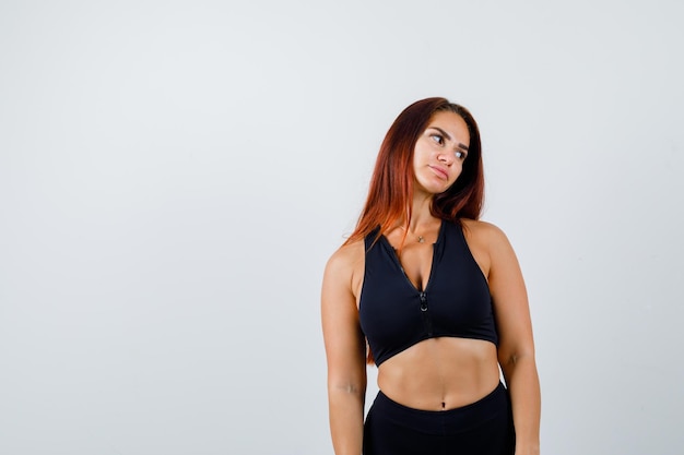 Young sporty woman with long hair in a black top