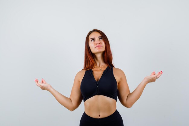 Young sporty woman with long hair in a black top